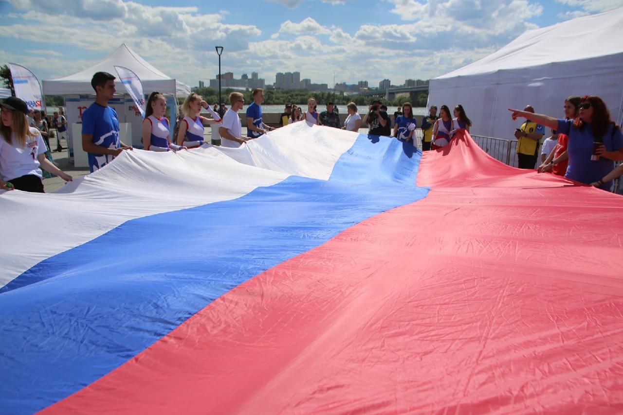 Фото Участник спецоперации на Украине и олимпийская чемпионка подняли флаг России в Новосибирске 12 июня 2